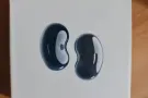 一个Galaxy Buds Live 黑色耳机和一个无线充电charger